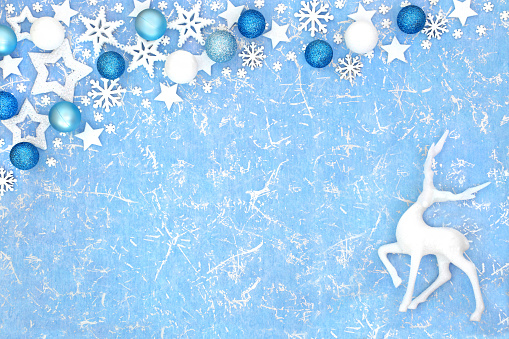 Christmas reindeer background with snowflake, star and bauble decorations on blue background. North pole fantasy happy holidays design for Yule, Noel, New Year season.