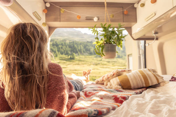 istock Woman lying down in her camper van, beautiful mountain view 1639724026