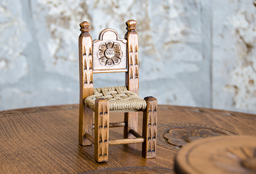 Miniature wooden hand made chair and table on carved table