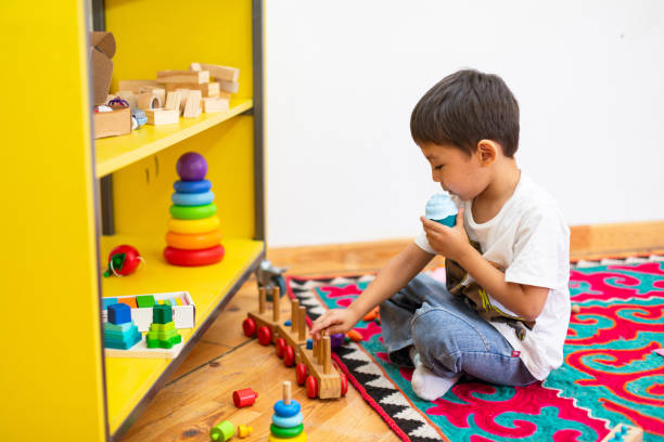 istock Boy playing with wooden train toy in kindergarten 1639781861