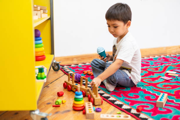 istock Boy playing with wooden train toy in kindergarten 1639782375