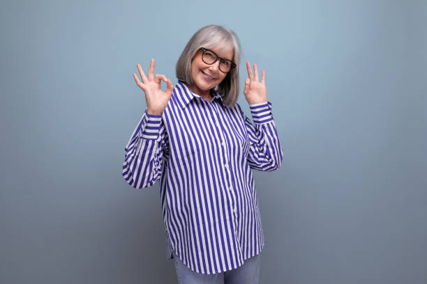 istock stylish mature old lady in a trendy shirt on a bright studio background with copyspace 1639802715