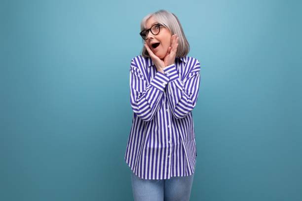 istock surprised middle-aged youth lady with gray hair on a bright studio background with copy space 1639803231