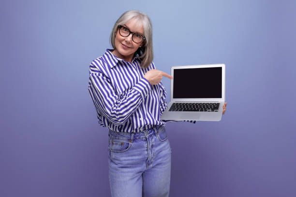 밝은 스튜디오 배경에 모형이 있는 노트북을 사용하여 새로운 직업을 배우는 현대 연금 수급자 여성 - senior adult aging process old backdrop 뉴스 사진 이미지