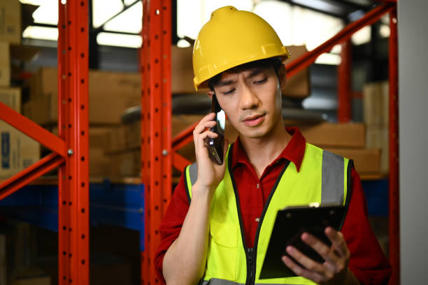 istock Serious male manager in reflective jacket talking on mobile phone while standing in a retail warehouse 1639817191