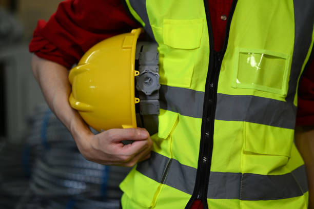 Unrecognizable male worker holding hardhat standing in retail warehouse. Logistics, and manufacture storehouse occupation