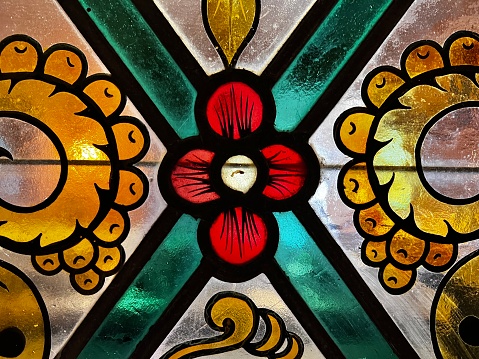 Stained glass flowers and knife in church.