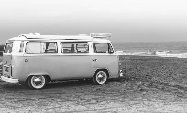 Classic Volkswagen T2 Caravette parked on a beach overlooking the surf