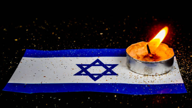 istock Israeli flag and candles burning above it, Holocaust memory day 1639840171