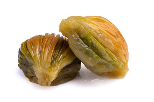 Mussel shaped baklava with pistachio on white background