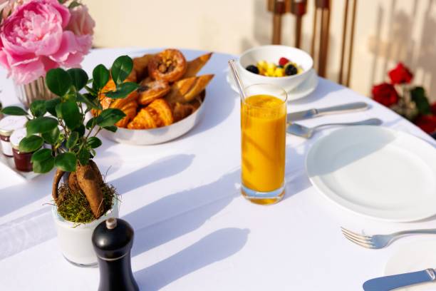 istock Continental breakfast served on a white tablecloth outdoors at sunrise with fresh orange juice 1639856218