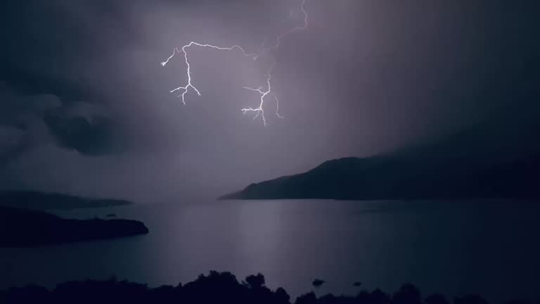 lightning storm in the night under mountain lake