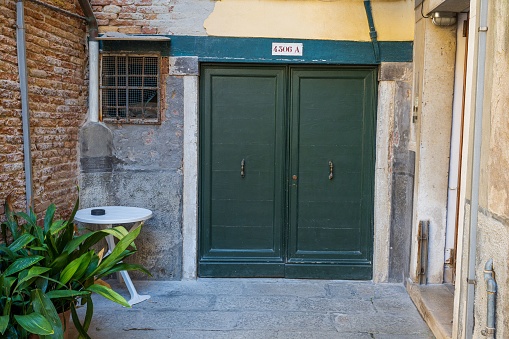 Venice, Italy – June 16, 2023: Entrance to a building along narrow ally in Venice, Italy.