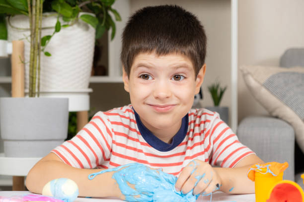 istock A six-year-old boy plays with slime while sitting at a table at home. A toy for the development of fine motor skills and creativity in children 1639963289
