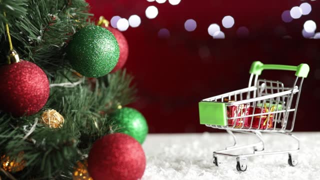 christmas shopping trolley with gifts and presents on background of Christmas tree and lights with copy space