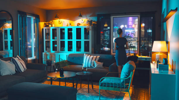 istock Neon City Glows Through Woman's Apartment Window 1639964357