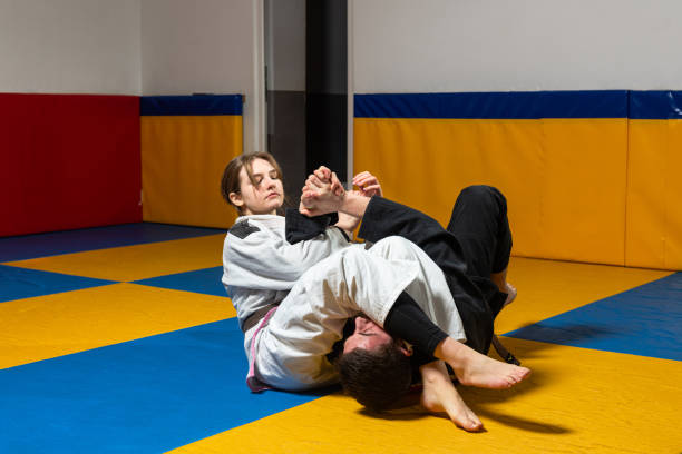 menina e menino praticam jiu jitsu brasileiro na academia - wrestling mat - fotografias e filmes do acervo