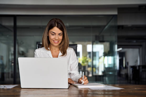 istock Middle-age Hispanic woman using laptop computer for business studying, watch online virtual webinar training meeting,video call. Focused mature 40s years Latin businesswoman work in office, copy space 1640021999
