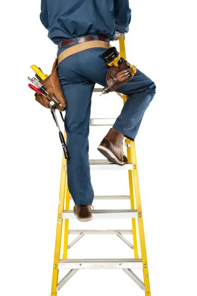 Photo of Handyman In Uniform And Tool Belt  Climbing Ladder