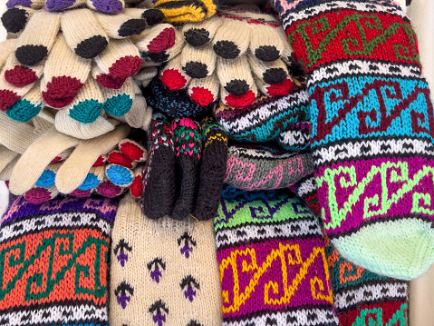 knitted clothes, beautiful knitted woolen socks and gloves in a local market or bazaar in Turkey. traditional vintage clothing concept in Turkey. turkish craft products background, selective  focus