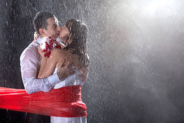 Happy wedding lovers on strong rain Married couple having the longest kiss on extremely big rain. gay wedding kiss stock pictures, royalty-free photos & images