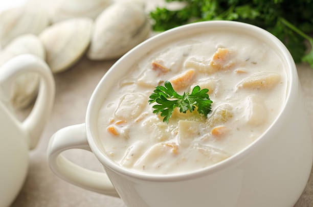 Clam Chowder Classic New England style clam chowder served in a cup with parsley garnish and clams in the shell. Chowder stock pictures, royalty-free photos & images
