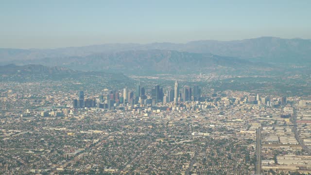 Aerial view showcasing the vast expanse of Los Angeles cityscape with its skyscrapers in 4k slow motion 60fps