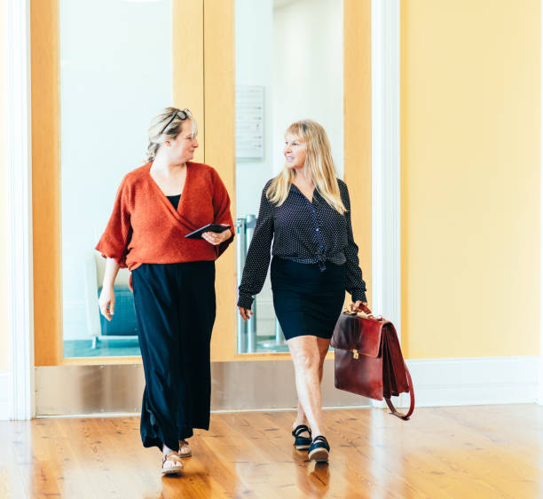 istock Two female professionals walk and have a discussion in a professional modern office 1640096782