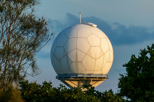 The weather measuring installation at Sydney Kingsford-Smith Airport, which has the appearance of a very large golf ball.  This image was taken from Shep's Mound on a windy, cold and sunny afternoon at sunset on 25 August 2023.