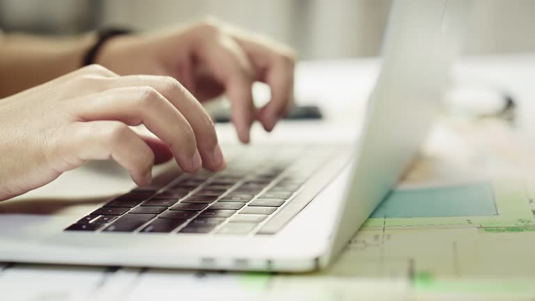 Hands of a person busy typing on a keyboard using a Laptop