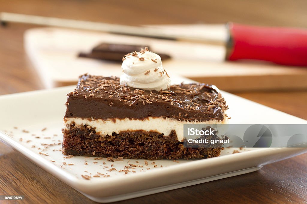 Chocolate Cream Cake - Horizontal a photo of a slice of a chocolate-cream cake, placed on a plate and garnished with chocolate shavings.  this sweet dessert is made of layers of chocolate cake, whipped topping and cream cheese, and pudding, baked and chilled to perfection. Cake Stock Photo
