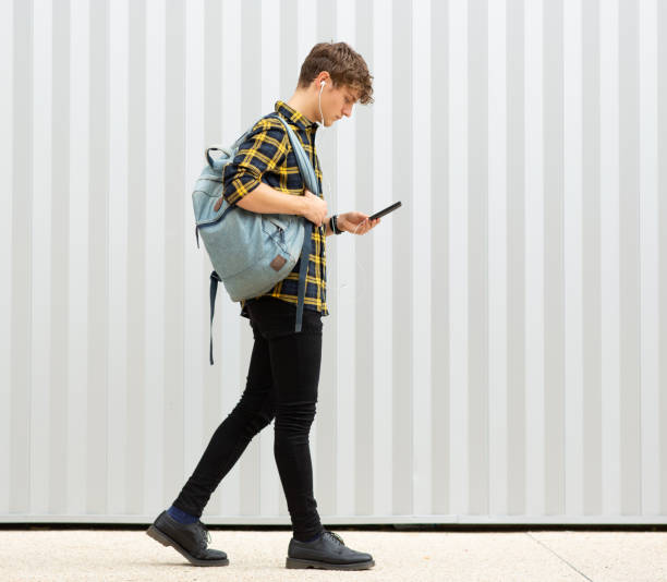 istock Young man walking outside with phone and earphones 1640114329