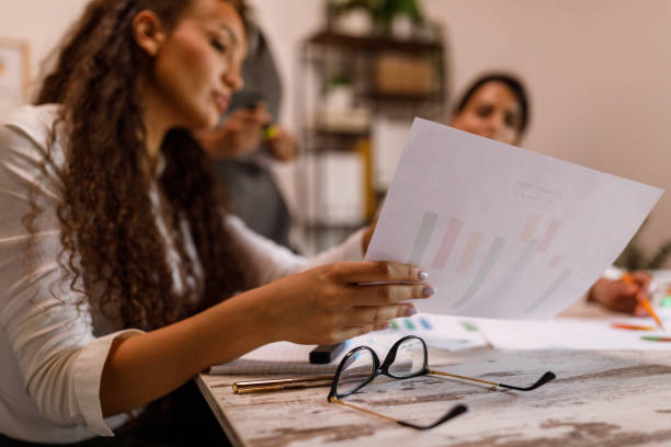 istock Young woman checking reports and charts, working on a project with colleagues at the office 1640118186