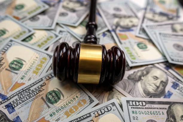 istock wooden hammer on one hundred dollar bill 1640142839