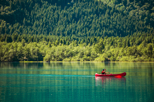 Glacial Lake Canoeing. Caucasian Sportsman in the Kayak on the Turquoise Water. Norwegian Expedition.