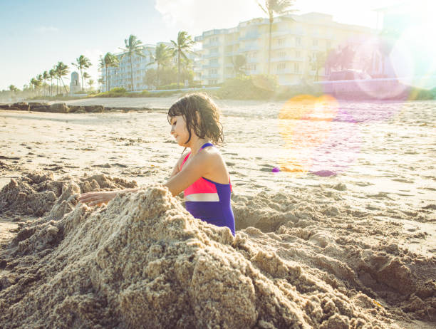 istock Cute child on an idyllic beach digging and building a sand castle 1640152606