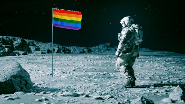 istock Rainbow colored flag is planted on the surface of a planet or moon 1640155639