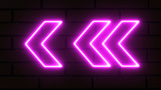 Glowing directional left arrow neon sign. Set of bright purple neon light arrows pointing to the left. Flashing direction indicators. 3D rendering of glowing neon arrows on a bricks background