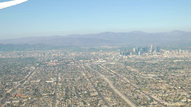 Aerial view showcasing the vast expanse of Los Angeles cityscape with its skyscrapers in 4k slow motion 60fps