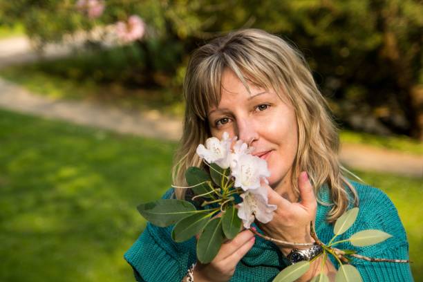 istock Blonde woman posing with magnolia flowers 1640206540
