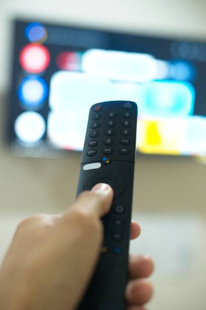 istock Hand with TV remote control, switching TV series from streaming service platform. The new way of enjoying entertainment at home. 1640213232