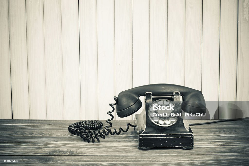 Vintage telephone on old table sepia photo Aging Process Stock Photo