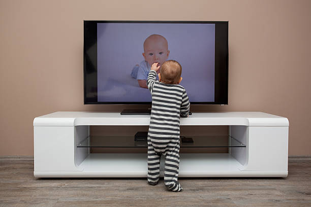 istock Toddler touching a baby on the television 164022347