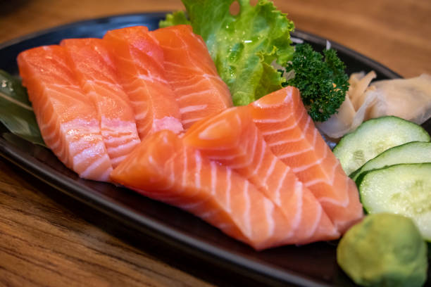 istock Salmon sashimi with vegetable on plate, served in a restaurant 1640223774