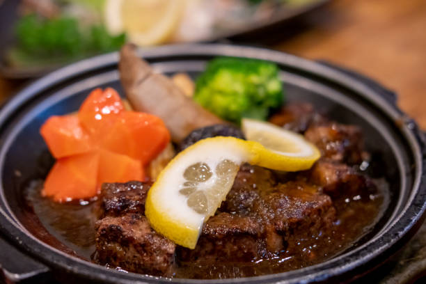 Diced meat steak served on plate with lemon, carrot and vegetable