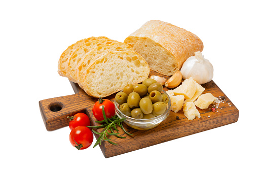 Ciabattas, olive oil in a bowl with olives, raspberry herbs, spices, garlic, cherry tomatoes, parmesan and ciabatta bread isolated on white background.Banner. Healthy food concept.Delicacy.