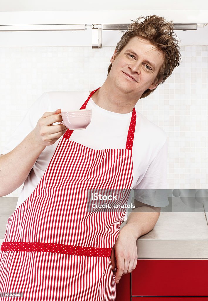 Man in apron Man in apron standing in kitchen with coffee cup Adult Stock Photo