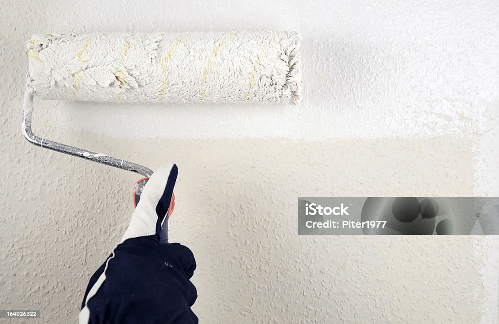 Painting white Worker hand with paint roller Acrylic Painting Stock Photo