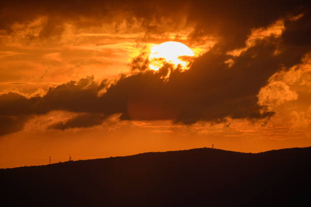 istock At dusk, the sun is sometimes covered by dark clouds and sometimes exposed. 1640275588