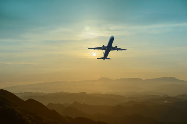 istock A airplane fly across the evening sky, dynamic clouds, misty mountains. 1640277366